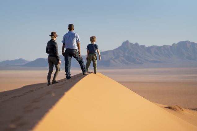 Family at top of dune looking at view Kwessi Dunes