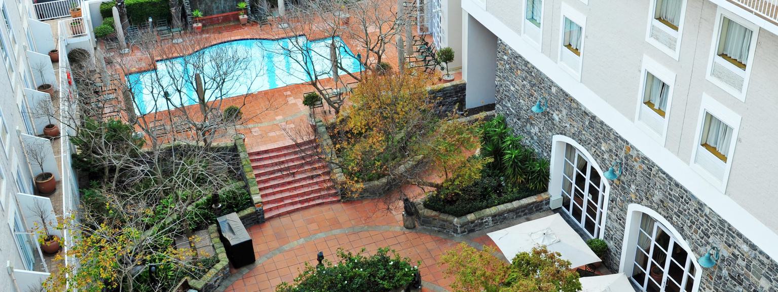 Aerial view of hotel courtyard with pool and plants.