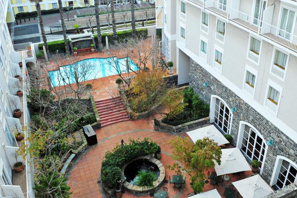 Aerial view of hotel courtyard with pool and plants.