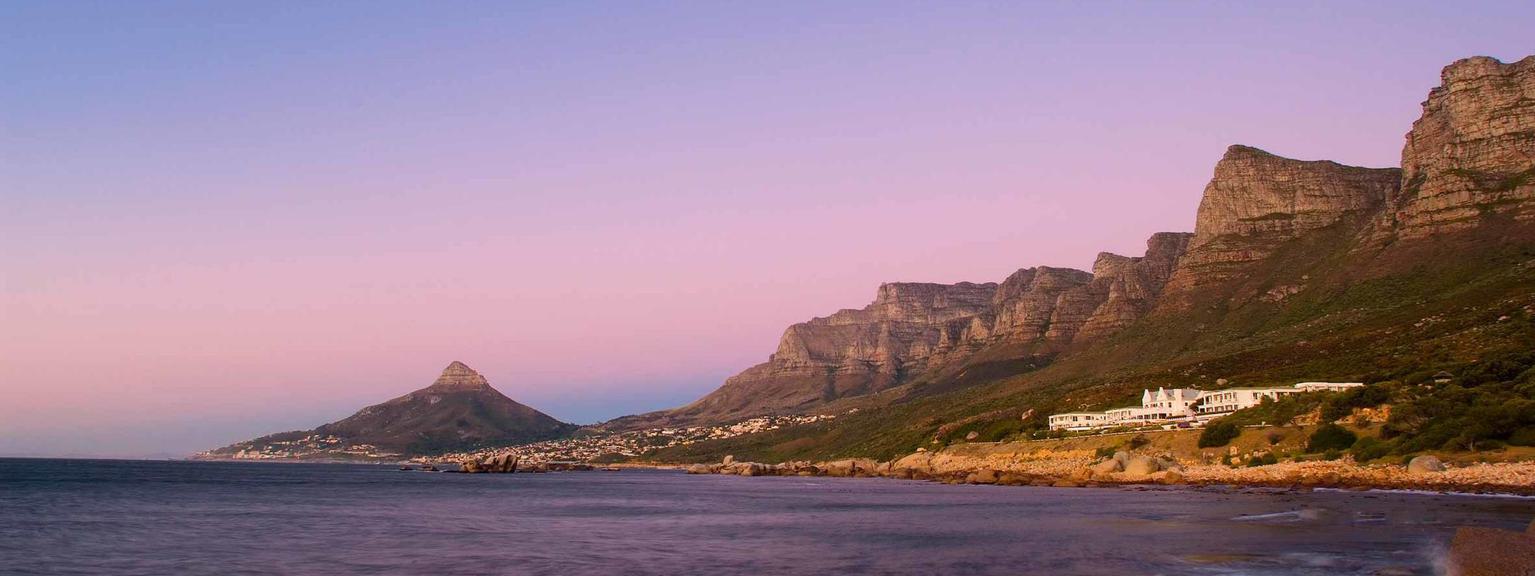 Sea and The Twelve Apostles Hotel at sunset with Twelve Apostles and Lion's Head Cape Town in background