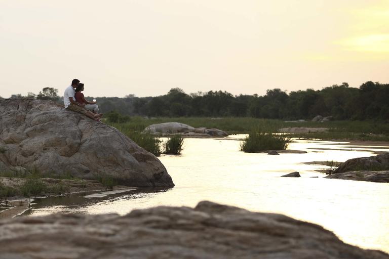 Romantic couple on rocks by river and Beyond Kirkman s Kamp