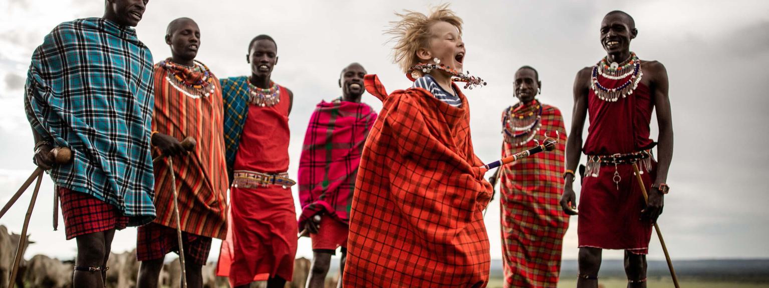 Child jumping joy maasai warrior House in the wild